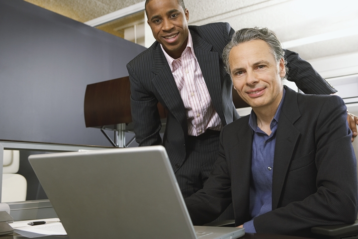 Two people over a laptop