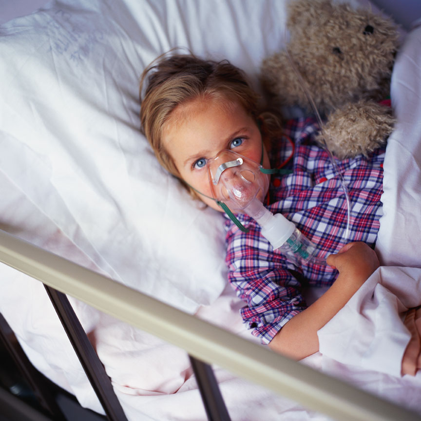 Child in hospital bed with oxygen mask