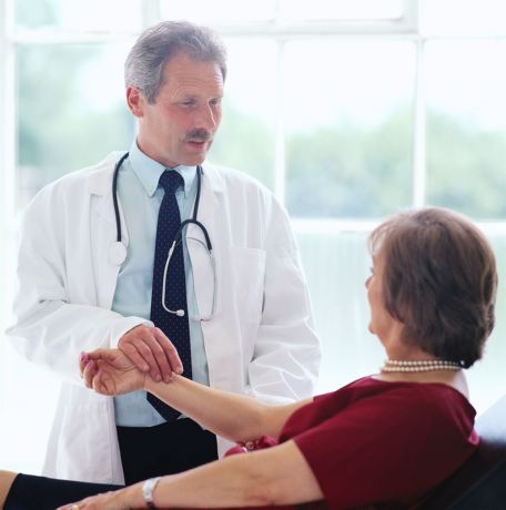 Male Physician Taking Female Patient's Blood Pressure