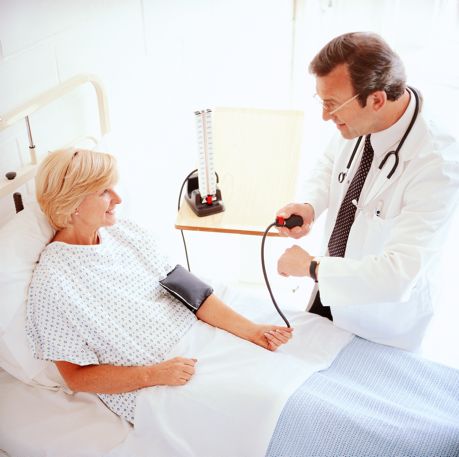 Physician taking woman's blood pressure